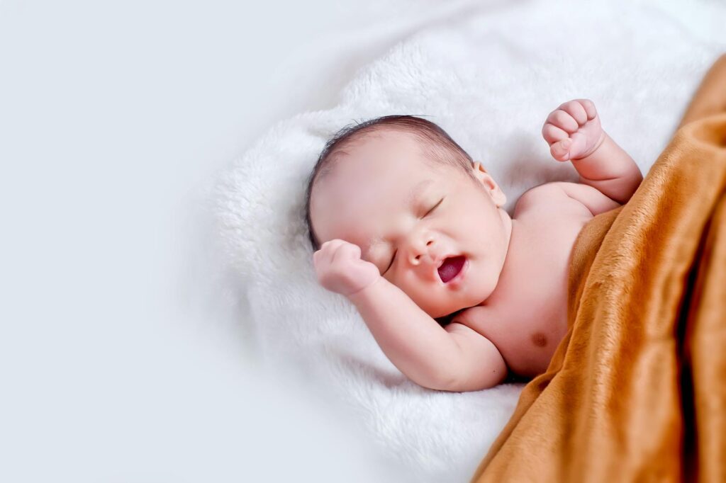 Desenvolvimento Infantil de 0 a 1 ano Imagem atual: baby lying on white fur with brown blanket